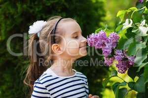Girl smelling lilac flowers