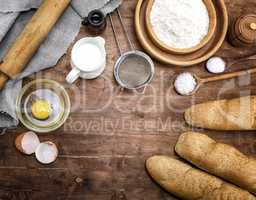 white wheat flour in a wooden bowl and baked baguettes