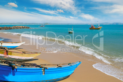 Fishing boat on the sandy shore against a background the ocean a