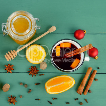 Hot red mulled wine on wooden background with orange slice, anis
