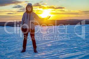 Woman in snow landscape with sunset