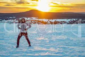 Woman in snow landscape with sunset