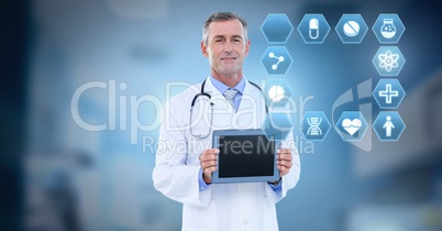 Male doctor holding tablet with medical interface hexagon icons