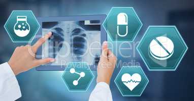 Doctor holding tablet with medical interface hexagon icons and x-ray