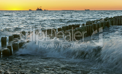 sunset on the sea, the waves beat against the breakwater, the sea at dawn, the ships on the horizon