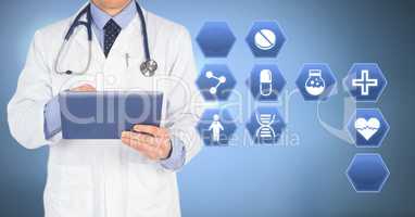 Male doctor holding tablet with medical interface hexagon icons