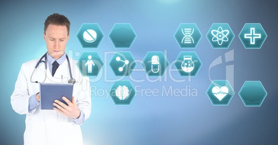 Male doctor holding tablet with medical interface hexagon icons