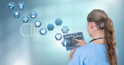 Female doctor holding tablet with medical interface hexagon icons