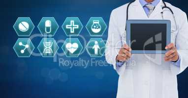 Male doctor holding tablet with medical interface hexagon icons