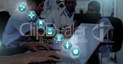 Doctor using laptop with medical interface hexagon icons