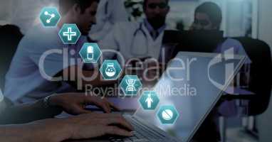 Doctor using laptop with medical interface hexagon icons