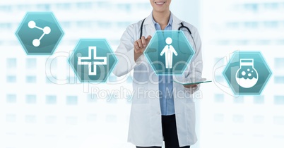 Female doctor holding tablet with medical interface hexagon icons