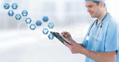 Male doctor holding tablet with medical interface hexagon icons