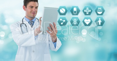 Male doctor holding tablet with medical interface hexagon icons