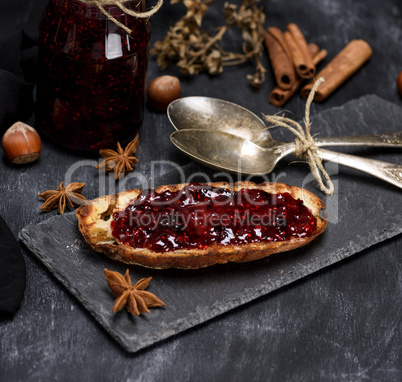 toast with raspberry jam, two iron spoons