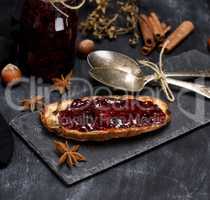 toast with raspberry jam, two iron spoons