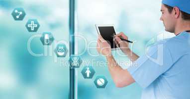 Male doctor holding tablet with medical interface hexagon icons