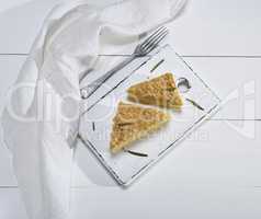 two pieces of Napoleon cake on a white wooden board