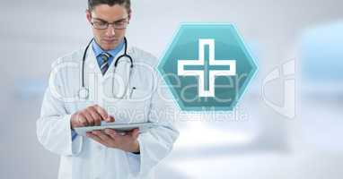 Male doctor holding tablet with medical cross interface hexagon icon