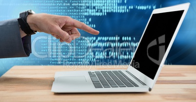 Hand pointing at laptop with coding text