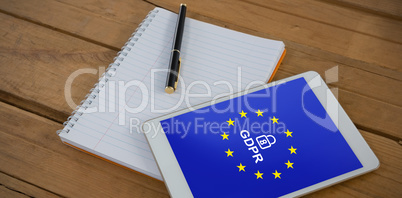 Composite image of blank notepad and digital tablet on wooden plank