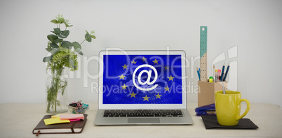 Composite image of laptop and various office accessories on table