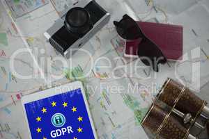 Composite image of passport, camera, binoculars and digital tablet on map