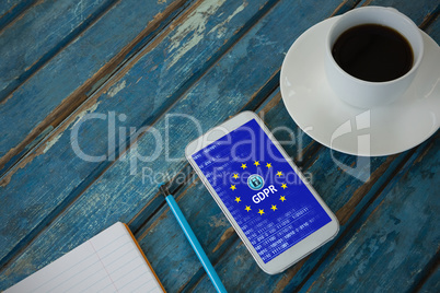 Composite image of black coffee, mobile phone, pencil and book on wooden plank