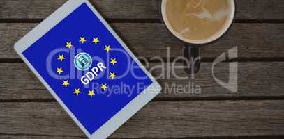 Composite image of digital tablet and cup of coffee on wooden plank