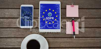 Composite image of black coffee, mobile phone, digital tablet, pen and sticky note on wooden plank