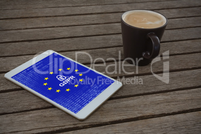 Composite image of digital tablet and cup of coffee on wooden plank