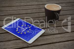 Composite image of digital tablet and cup of coffee on wooden plank