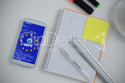 Composite image of mobile phone and stationery on white background