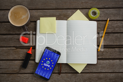 Composite image of organizer, coffee, mobile phone and stationery on wooden plank