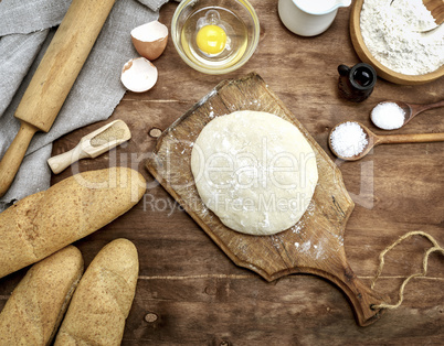 yeast dough made from white wheat on a brown wooden board