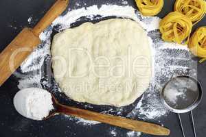 white wheat flour pasta and wooden rolling pin