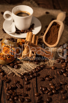 Cup of coffee with cinnamon and dried orange fruit