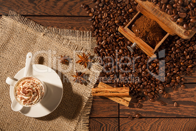 Coffee cup, star anise, cinnamon sticks and coffee-beans