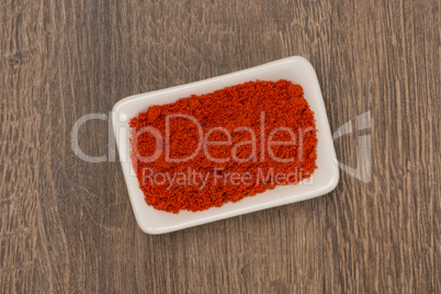 Red pepper powder over wood background
