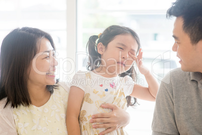 Parents comforting crying daughter