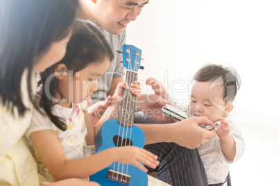 Family playing ukulele and harmonica at home