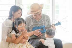 Asian family playing ukulele