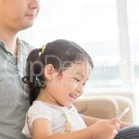 Father and child using digital tablet.