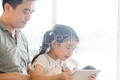Father and child playing with tablet pc.