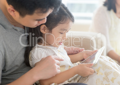Father and daughter playing with tablet pc.