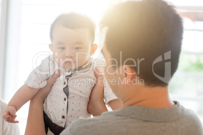 Father holding baby son.