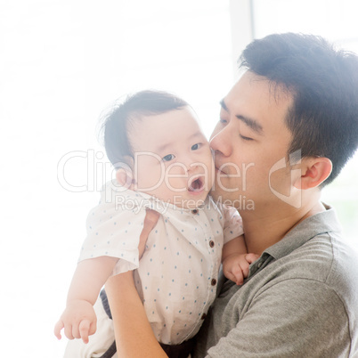 Father kissing baby boy.