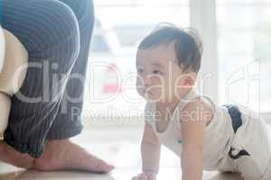 Baby boy crawling towards father.