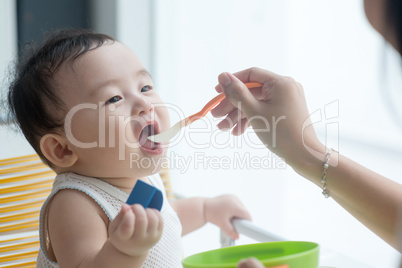 Mother feeding baby boy.