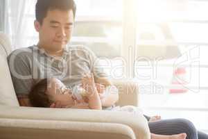 Father bottle feed milk to toddler.